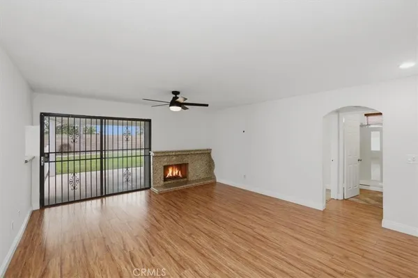 a view of an empty room with wooden floor and closet