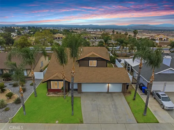 an aerial view of residential houses with outdoor space and trees