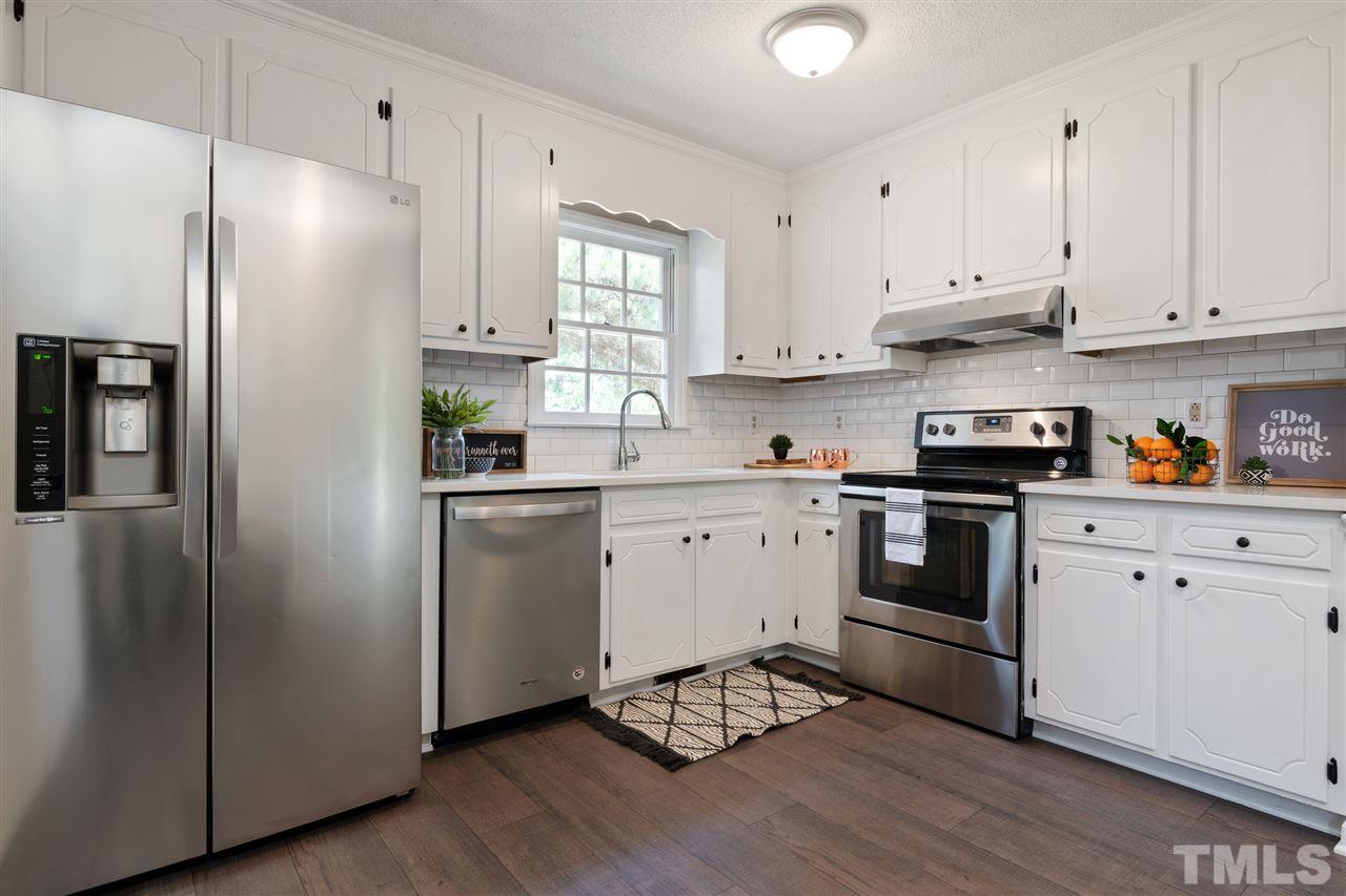 3324 Castlegate Drive Raleigh, NC 27616 - Photo 7 of 26 a kitchen with cabinets stainless steel appliances and wooden floor