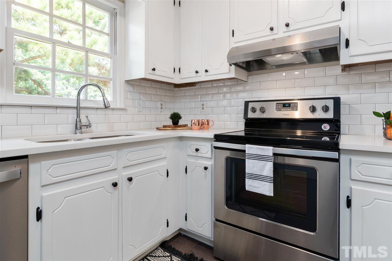 3324 Castlegate Drive Raleigh, NC 27616 - Photo 8 of 26 a kitchen with stainless steel appliances white cabinets and a stove a sink