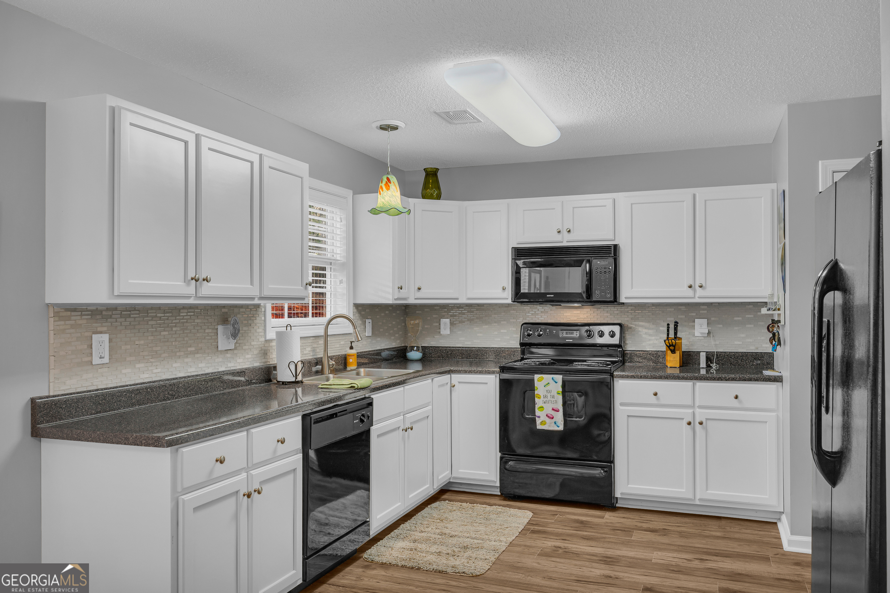 259 Watson Drive Hull, GA 30646 - Photo 27 of 47 a kitchen with granite countertop white cabinets and stainless steel appliances