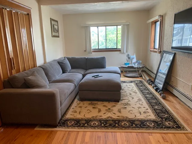 a living room with furniture window and a flat screen tv