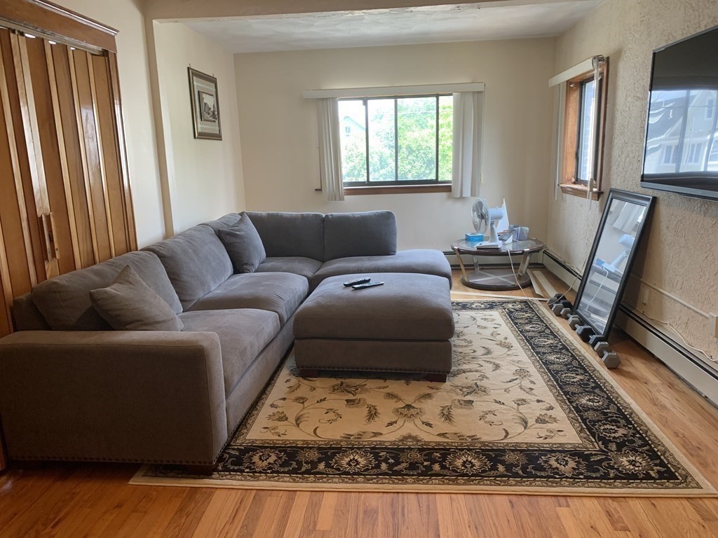 a living room with furniture window and a flat screen tv