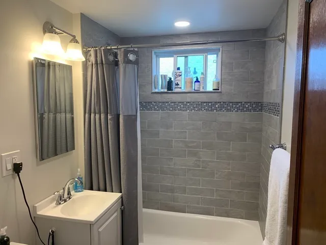 a bathroom with a sink mirror and shower
