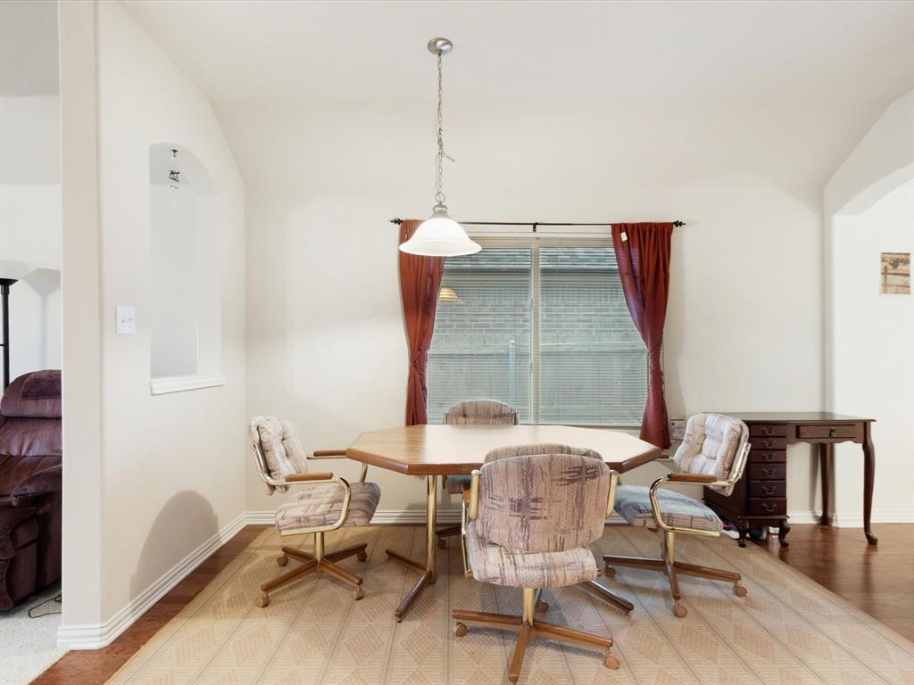 5440 Lavaca Road Grand Prairie, TX 75052 - Photo 11 of 22 Arched wall opening, window with horizontal blinds, overhead pendant light fixture, and wood-finish flooring