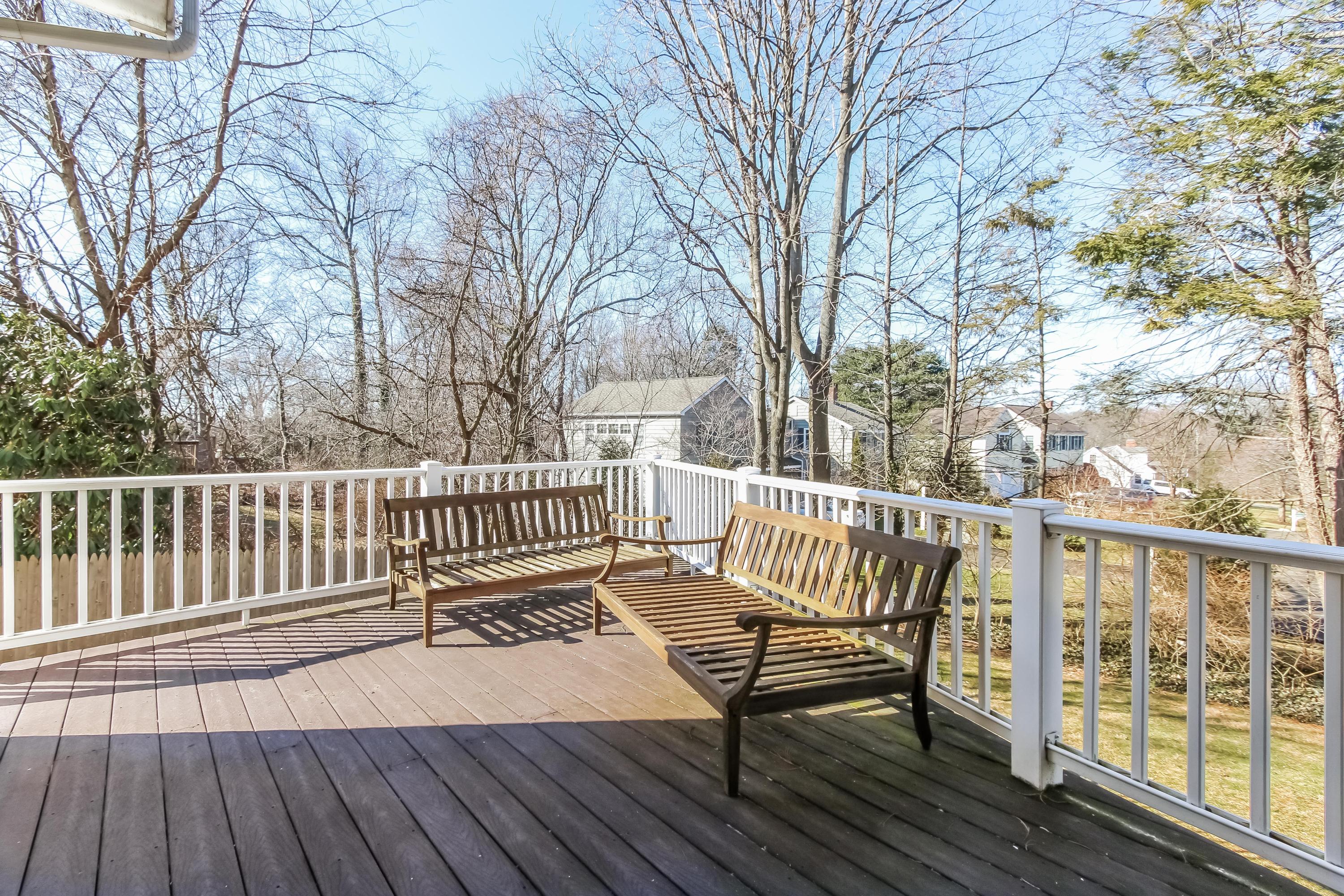 221 Hollow Tree Ridge Road Darien, CT 06820 - Photo 23 of 28 a view of a wooden deck with a bench and wooden floor