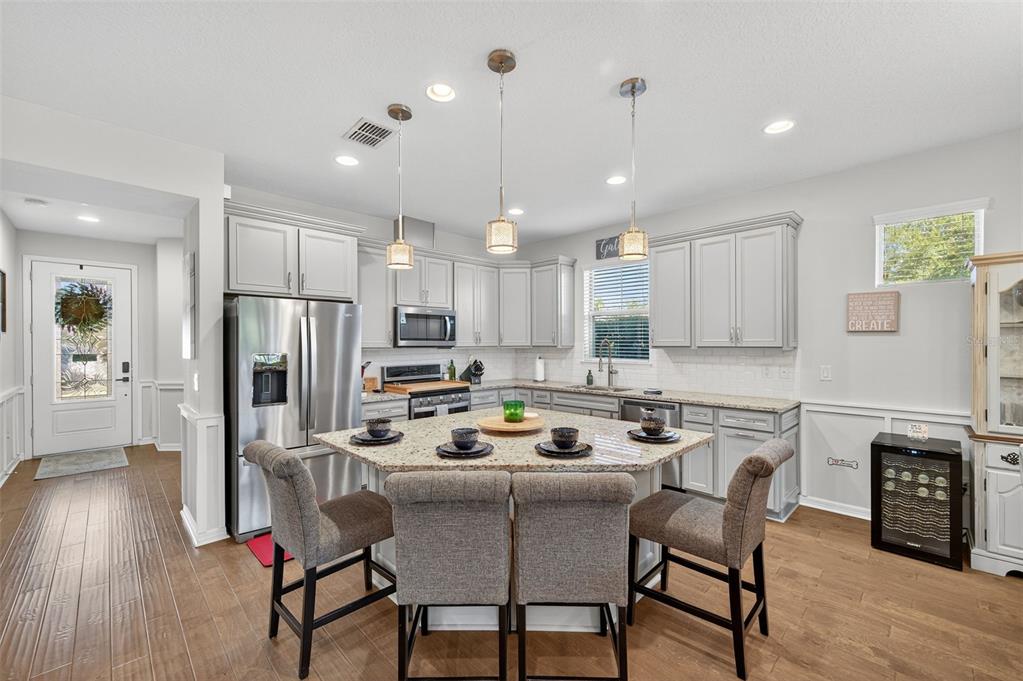 5706 Esker Falls Lane Lithia, FL 33547 - Photo 24 of 76 a kitchen with a dining table chairs refrigerator and microwave