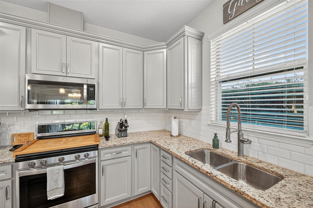 5706 Esker Falls Lane Lithia, FL 33547 - Photo 27 of 76 a kitchen with granite countertop a sink a stove and cabinets
