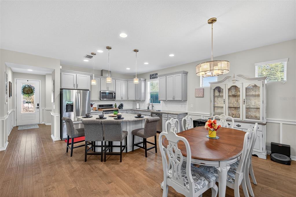 5706 Esker Falls Lane Lithia, FL 33547 - Photo 29 of 76 a view of a dining room and livingroom with furniture wooden floor a rug a painting and a chandelier