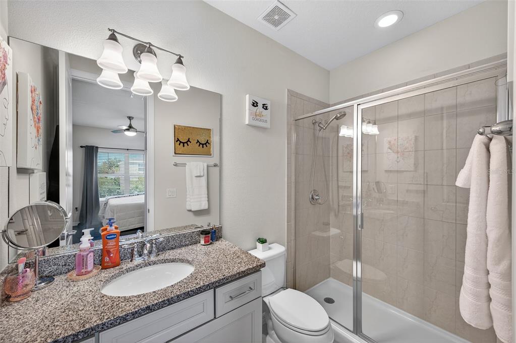 5706 Esker Falls Lane Lithia, FL 33547 - Photo 45 of 76 a bathroom with a granite countertop sink toilet a mirror a vanity and shower