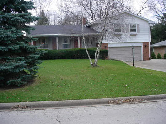 4851 Welsh Road Rockford, IL 61107 - Photo 1 of 6 a front view of a house with a garden and plants