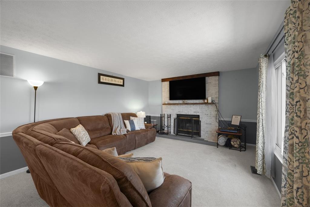 216 Briar Path Imperial, PA 15126 - Photo 10 of 39 a living room with furniture a fireplace and a flat screen tv