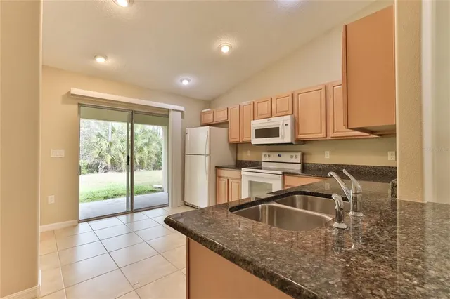 a kitchen with stainless steel appliances granite countertop a sink stove and cabinets