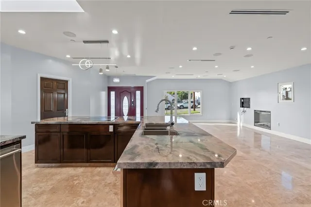 a large kitchen with kitchen island a stove a sink a dining table and chairs