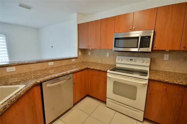 a kitchen with granite countertop cabinets stainless steel appliances and wooden cabinets