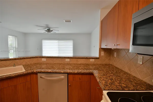 a kitchen with granite countertop a sink and a stove