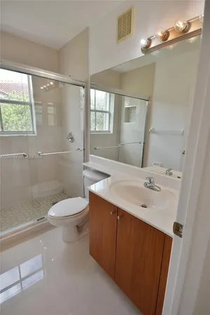 a bathroom with a sink a toilet and shower