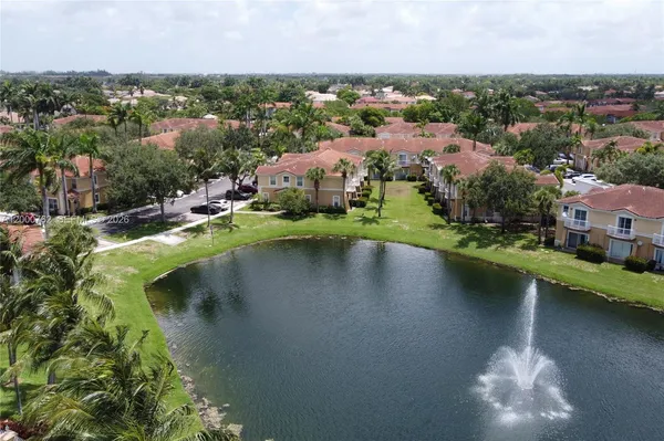 an aerial view of a house with a yard and lake view