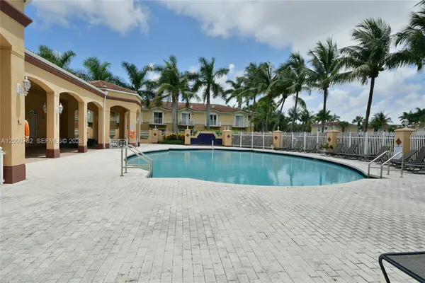 a view of swimming pool with palm trees
