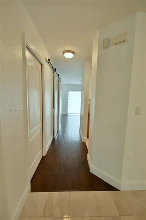 a view of a hallway with wooden floor