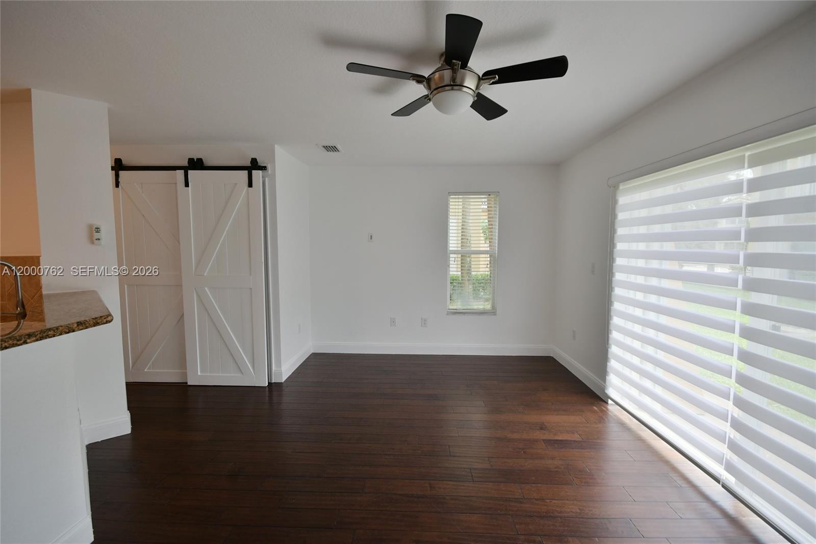 3177 Southwest 129th Way, Unit 134 Miramar, FL 33027 - Photo 8 of 34 an empty room with wooden floor fan and windows