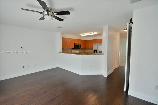 a view of a kitchen with wooden floor and a ceiling fan