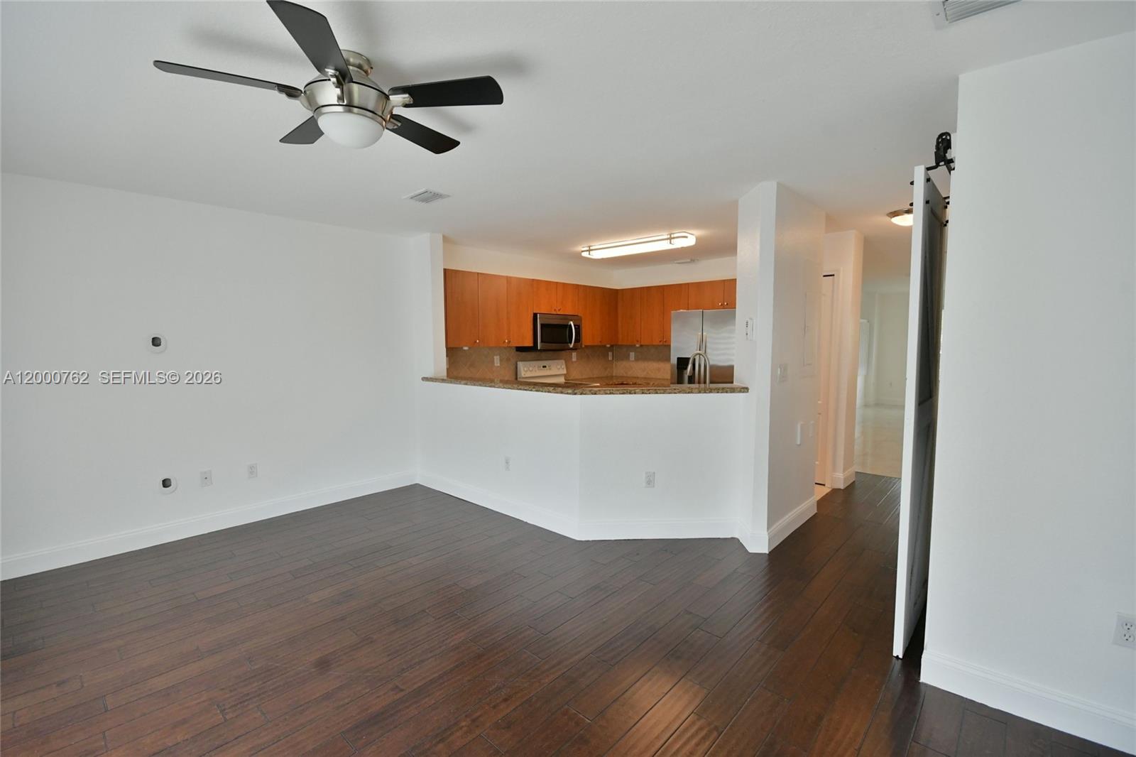 3177 Southwest 129th Way, Unit 134 Miramar, FL 33027 - Photo 9 of 34 a view of a kitchen with wooden floor and a ceiling fan