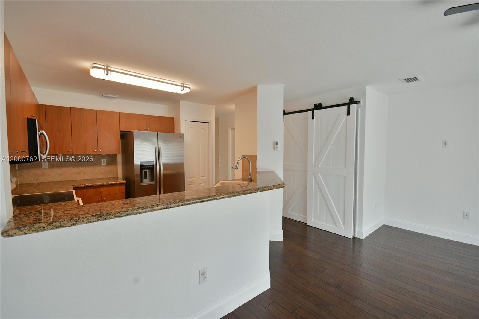 3177 Southwest 129th Way, Unit 134 Miramar, FL 33027 - Photo 10 of 34 a large kitchen with a refrigerator a sink and a large mirror