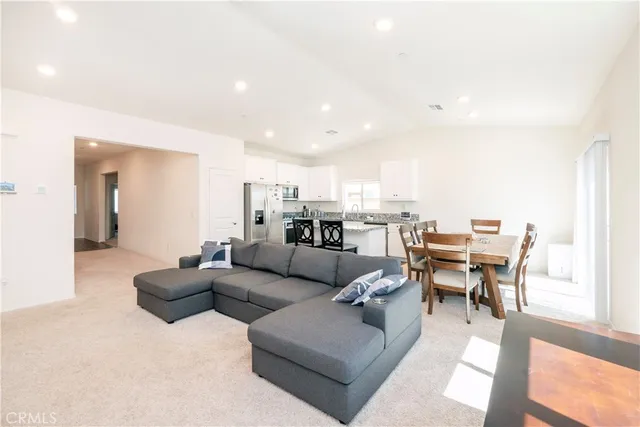 a living room with lots of furniture and view of kitchen