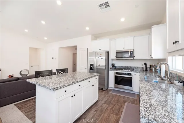 a kitchen with stainless steel appliances granite countertop a sink stove and cabinets