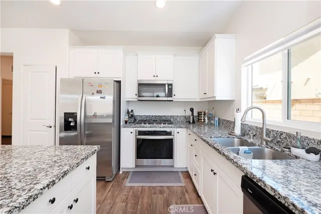 a large kitchen with granite countertop a sink stove a refrigerator and a granite counter tops