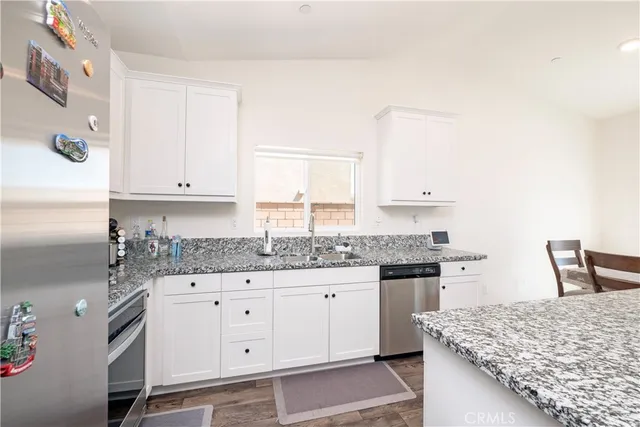 a kitchen with granite countertop a sink and cabinets
