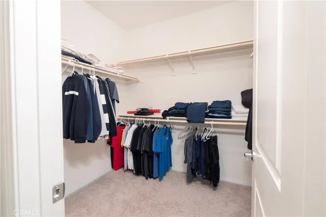 a view of walk in closet with clothes