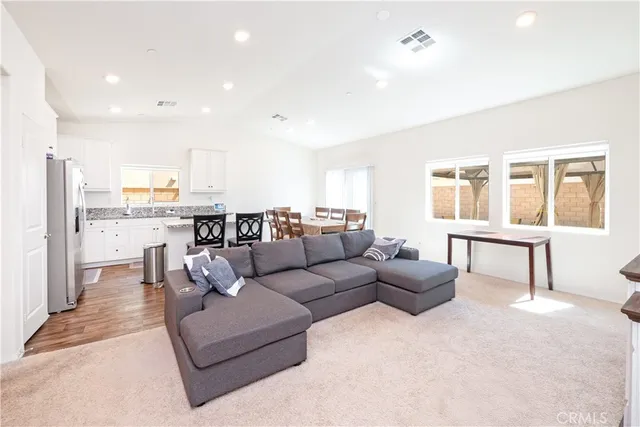 a living room with furniture and kitchen view