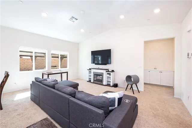 a living room with furniture a flat screen tv and a window