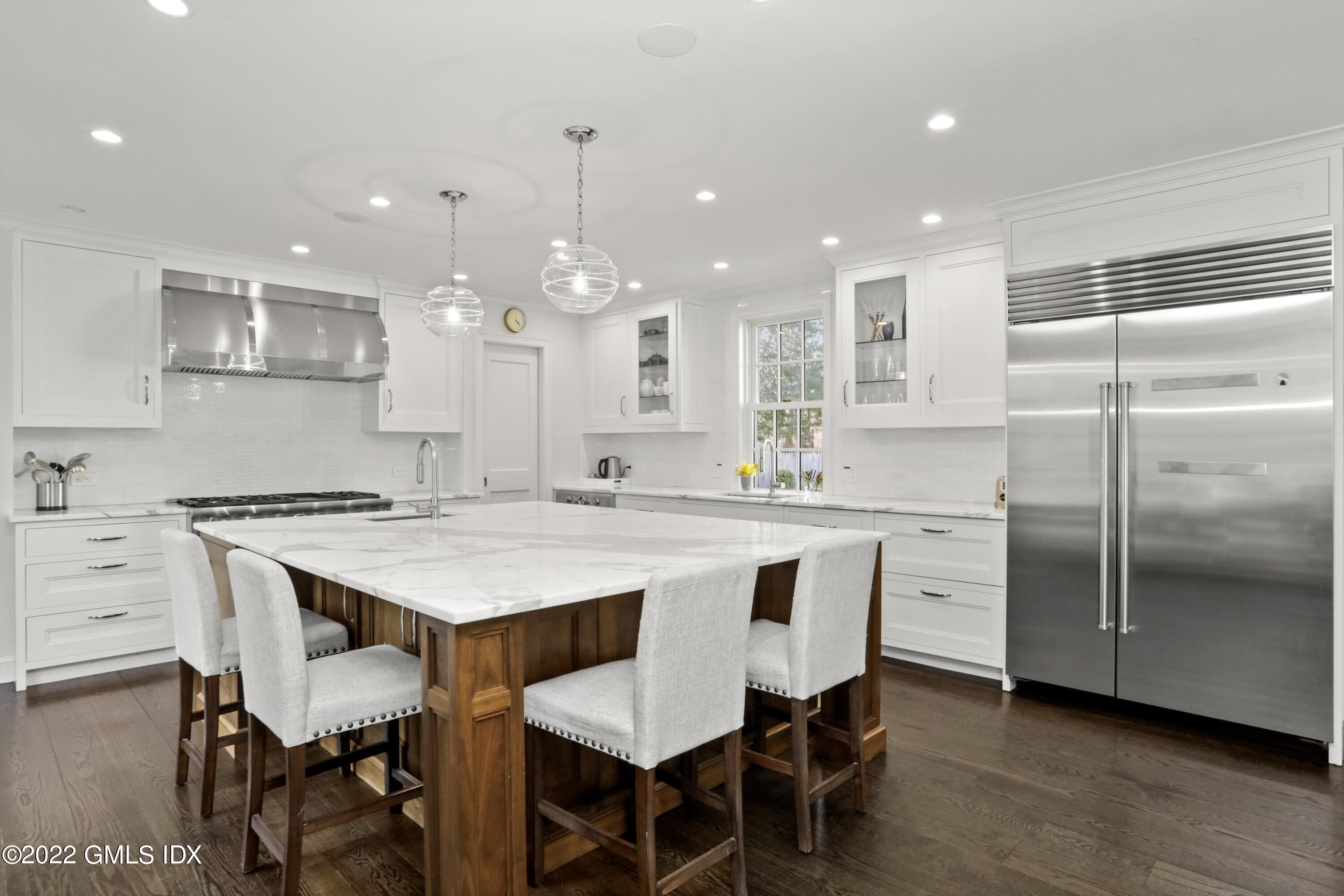 99 Husted Lane Greenwich, CT 06830 - Photo 7 of 27 a kitchen with kitchen island a dining table chairs sink and cabinets