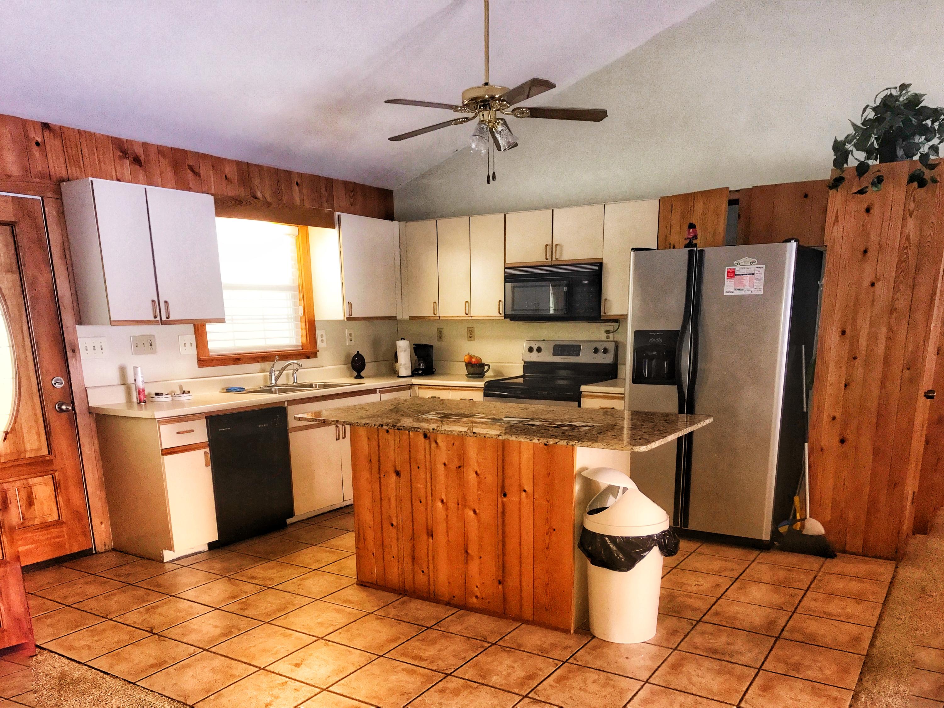 1326 Spring Lake Road DeFuniak Springs, FL 32433 - Photo 4 of 25 a kitchen with stainless steel appliances granite countertop a refrigerator a sink a stove a microwave and island