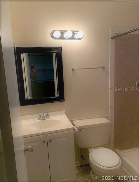 610 South Old County Road Edgewater, FL 32132 - Photo 2 of 10 a bathroom with a toilet a sink and mirror