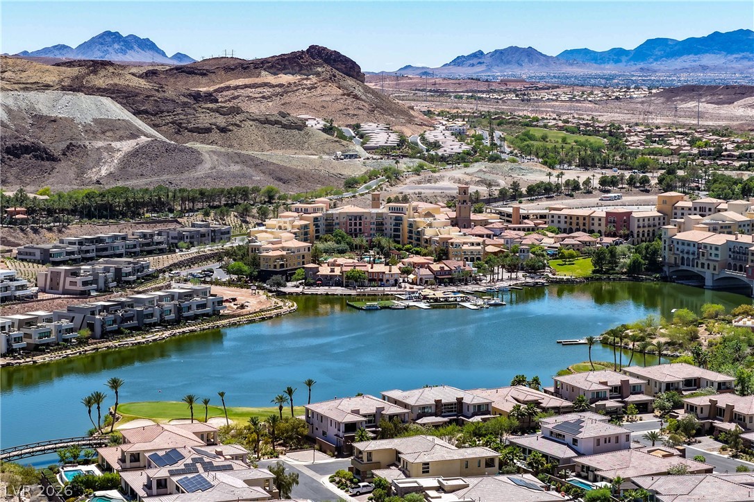 6 Rue Du Ville Henderson, NV 89011 - Photo 98 of 99 This aerial view showcases a vibrant waterside community nestled against a rugged mountain landscape.