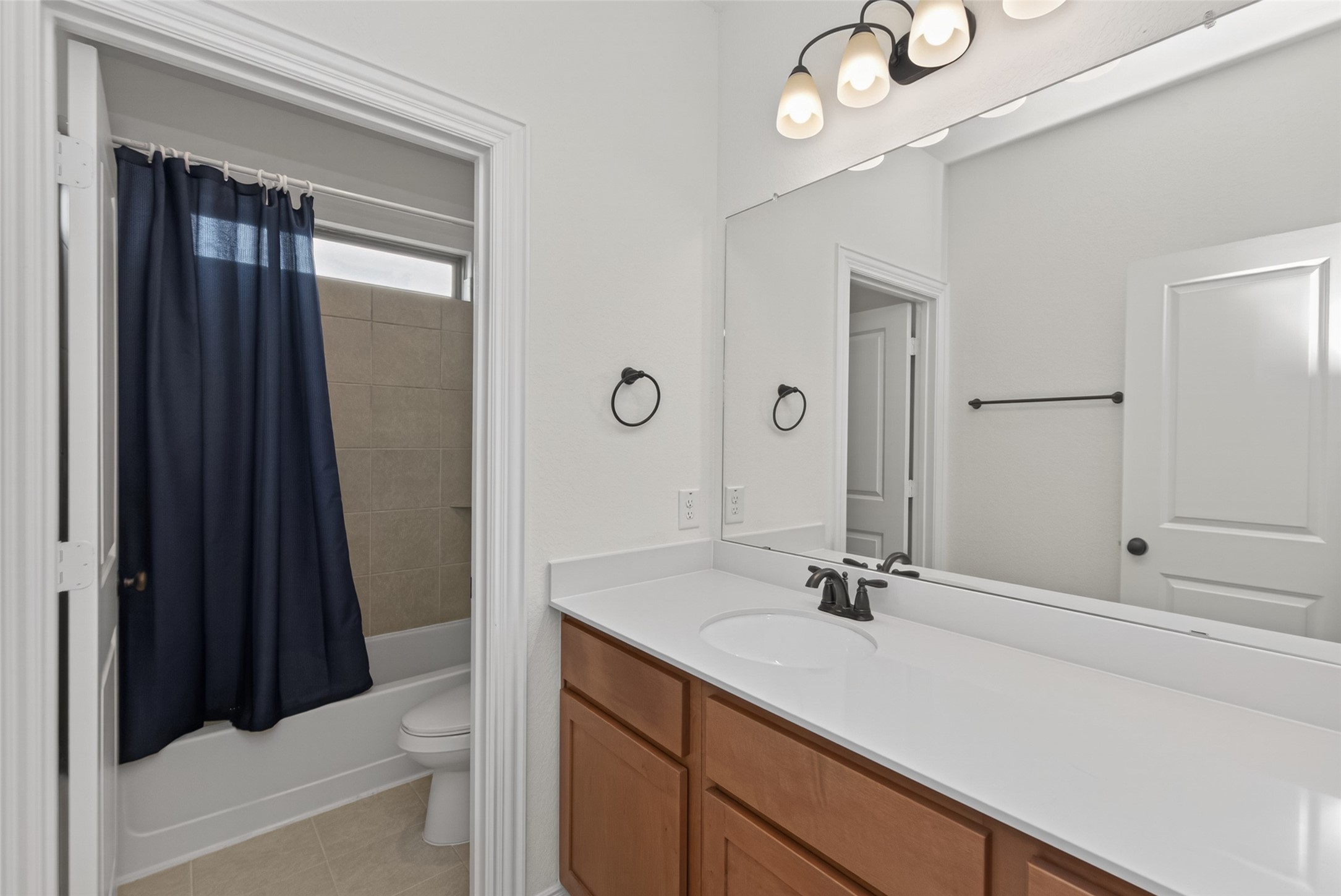 20802 Mirror Point Drive Cypress, TX 77433 - Photo 16 of 37 This bathroom boasts a sizable mirror over a generous countertop with ample storage. The room offers a bathtub combined with a tiled shower, all illuminated by contemporary lighting.