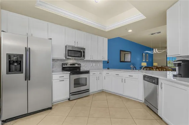 a kitchen with granite countertop stainless steel appliances and white cabinets