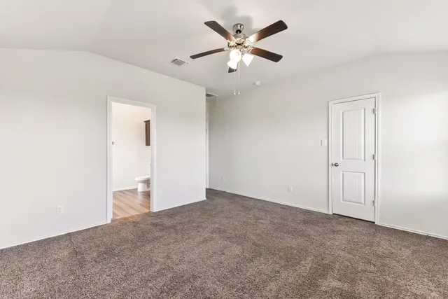 an empty room with a ceiling fan and a window