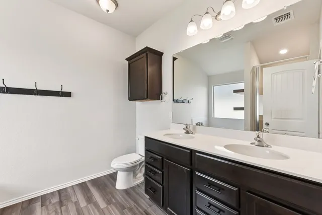 a bathroom with a sink a toilet and a large mirror