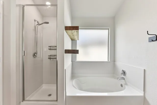 a white bath tub sitting next to a shower
