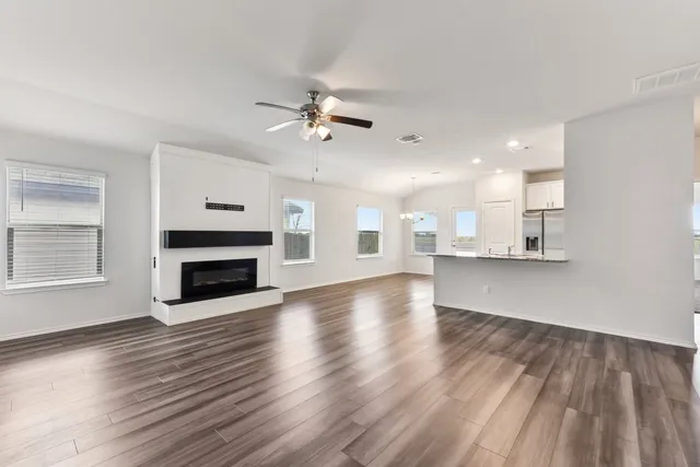a view of a kitchen with an empty room and a fireplace