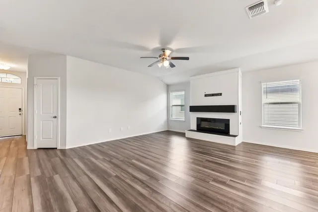 a view of empty room with wooden floor and fireplace