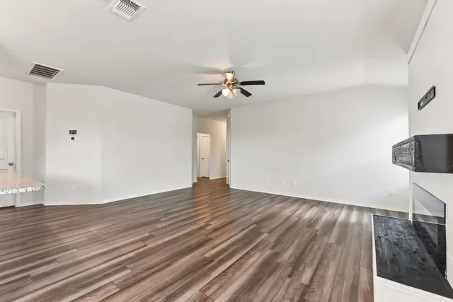 a view of a room with wooden floor and a ceiling fan