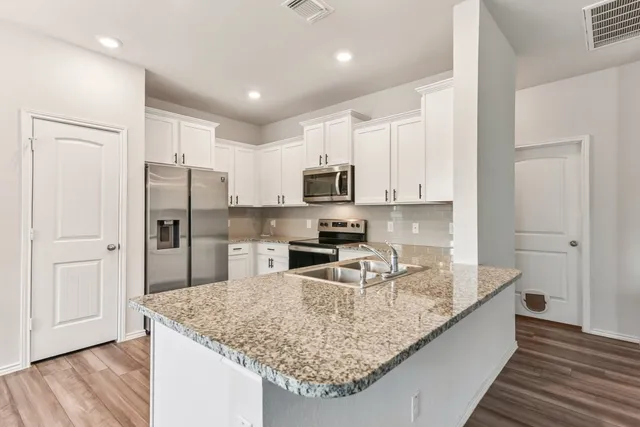 a kitchen with stainless steel appliances granite countertop a sink refrigerator and microwave
