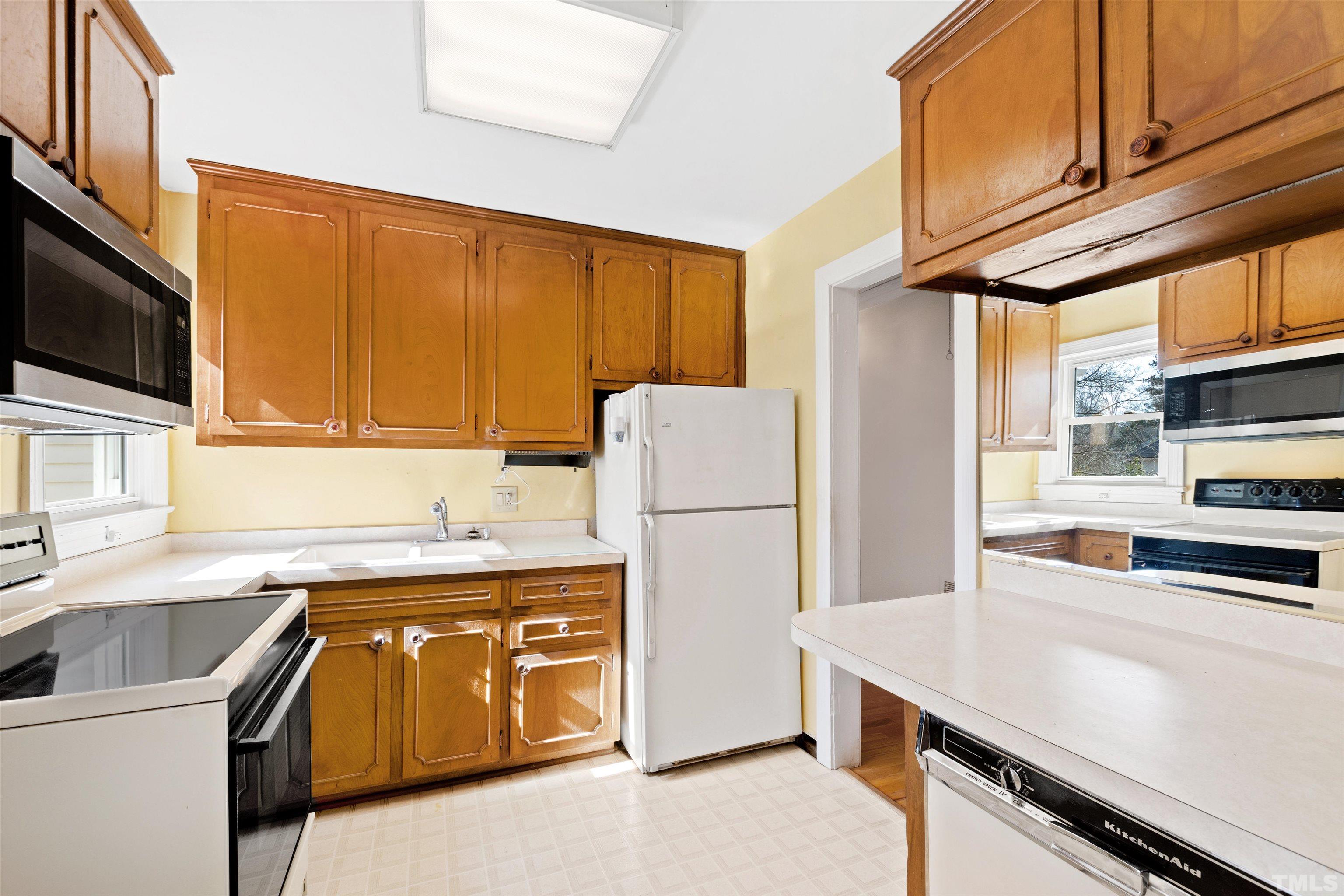2713 Gordon Street Raleigh, NC 27608 - Photo 12 of 35 a kitchen with a sink a stove and a refrigerator