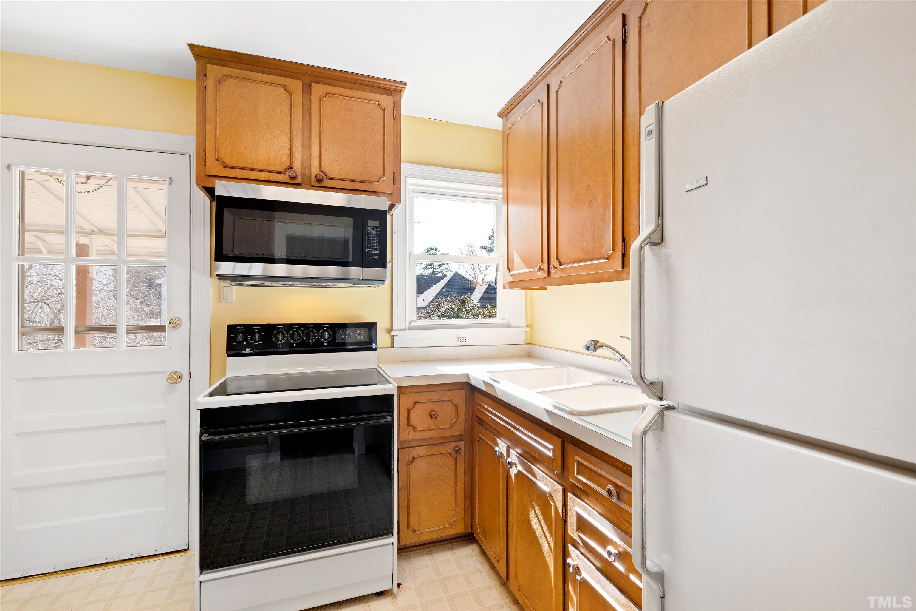 2713 Gordon Street Raleigh, NC 27608 - Photo 14 of 35 a kitchen with stainless steel appliances granite countertop a stove microwave and sink